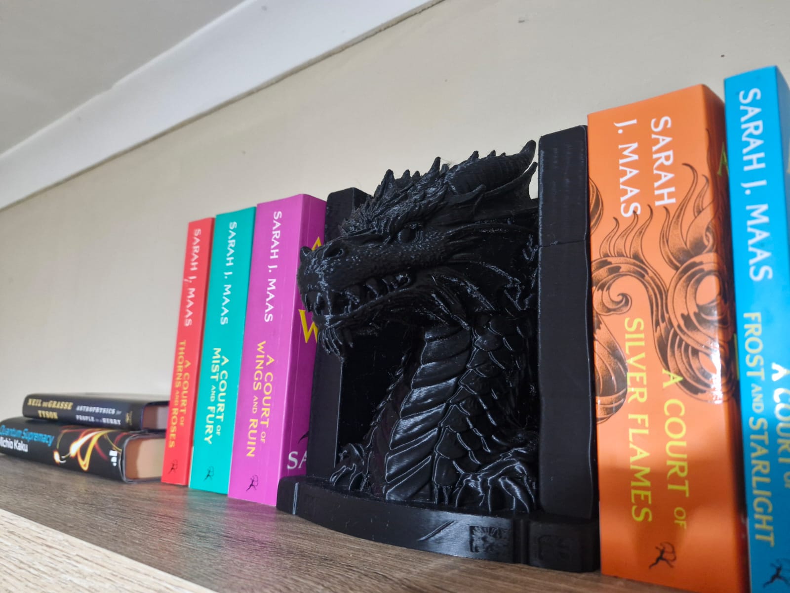 Close-up of a black dragon bookend on a bookshelf